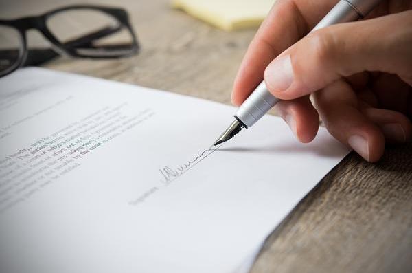 Close up of a contract being signed with a pen